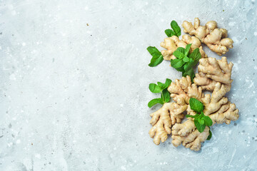 Wall Mural - Fresh ginger and green mint. Free space for text, on stone background.