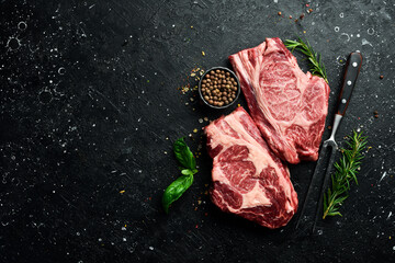 Wall Mural - Two Raw fresh marbled meat Steak Ribeye and seasonings on dark wooden background. Meat. Top view. Free space for text.