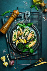 Wall Mural - Close up of delicious steamed mussels with basil and garlic. On a black stone plate. Seafood.