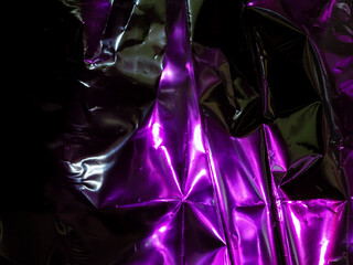 Wall Mural - purple reflections on foil in the dark for an abstract background.