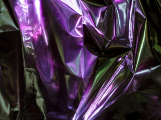 Wall Mural - purple reflections on foil in the dark for an abstract background.