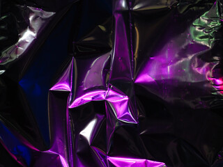 Wall Mural - purple reflections on foil in the dark for an abstract background.