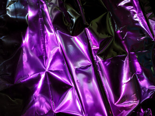 Wall Mural - purple reflections on foil in the dark for an abstract background.