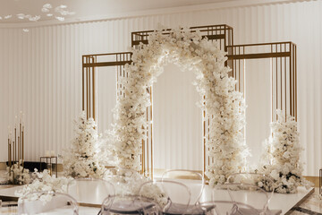 Wall Mural - Wedding arch decorated with white flowers in the luxury restaurant. Beautiful wedding set up in the luxury locale.