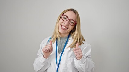 Wall Mural - Young blonde woman doctor doing thumbs up over isolated white background