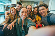 © Davide Angelini - Group of young tourists standing in youth hostel guest house - Happy multiracial friends booking summer vacation home - Guys and girls having fun taking selfie picture at summertime holidays
