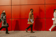 © qunica.com - Side view photo of business people walking on a red background