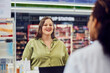 A happy female overweight customer talking with a female pharmacist.