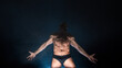 © Ulia Koltyrina - Muscular athlete in an epic pose, dark background, bright light from below, the concept of sports and bodybuilding