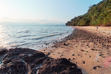 Wall Mural - Beach with sand, rocks, stones and blue sky.