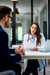 © bnenin - A female doctor reading blood test results and sitting with a male patient.