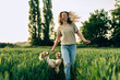 happy fulfilled woman running in a field with her dogs