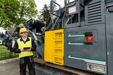 Aufkleber - Engineer with digital tablet next to road construction machine..
