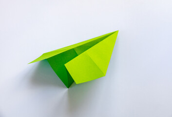 Wall Mural - green paper plane origami isolated on a white background