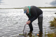 © Mat Hayward - Mature man releasing coho salmon back to the Egegik river in Alaska. He is pulling the hook from the mouth of the fish with pliers.