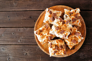 Smores brownies dessert platter. Top view on a rustic dark wood background.