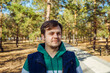 © Анастасия Бурлакова - Tired and unhealthy european caucasian white young male man in autumn Park or forest. Serious concerned Headshot man lifestyle portrait.