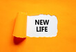 © Dzmitry - New life symbol. Concept words New life on beautiful white paper on a beautiful orange background. Business, support, motivation, psychological and new life concept. Copy space.