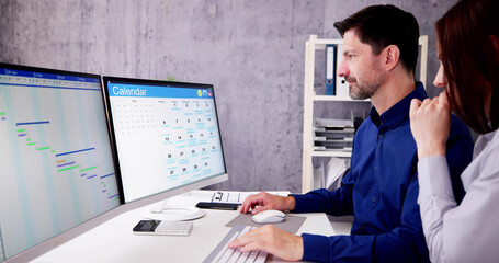 Poster - Employee Working On Calendar Schedule