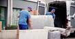 © Andrey Popov - Male Workers In Blue Uniform Unloading Furniture