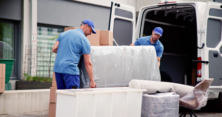Wall Mural - Male Workers In Blue Uniform Unloading Furniture