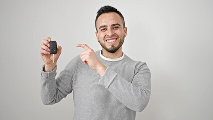 Poster - Hispanic man smiling confident pointing to key of new car over isolated white background