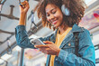 Closeup - Happy young African American woman passenger listening music via smart mobile phone in a train, Smile female wearing wireless headphones while moving in the tram, lifestyle, transportation