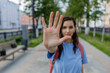 Female said stop it. Blurred portrait of young lady looking at camera extending hand forward saying no enoug. Focus on female palm close up raised in prohibiting gesture