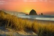 Haystack rock and the needles with beach grass in foreground on the Oregon coast at Cannon Beach