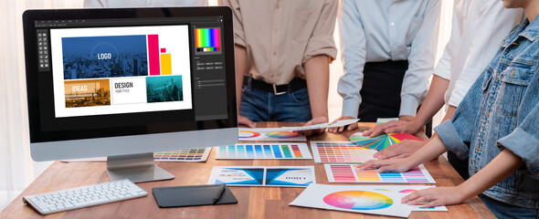 Poster - Graphic designer brainstorming logo and graphic art at busy artistic workshop, laptop display workspace. Experimenting color palette and pattern for creative design. Panorama shot. Scrutinize