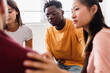 © Xavier Lorenzo - Therapy group people sitting in circle supporting each other talking at community center. Mental health and support concept.