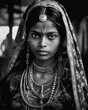 Portrait in B&W of an Indian woman wearing traditional clothes while working in an urban setting in India.