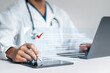 © Pakin - Doctor fills out the medical survey paperwork and checking mark on checkboxes.