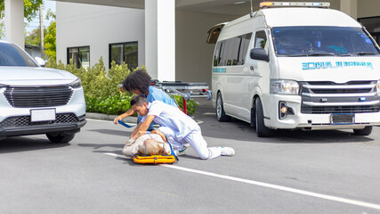 Wall Mural - Two paramedic rescuers helping a patient after having an accident. African nurse works with her colleague using stretcher to move a patient to ambulance van.