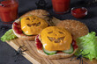 Two funny monster chicken burgers with toast cheese, ketchup and cucumber. Halloween food idea
