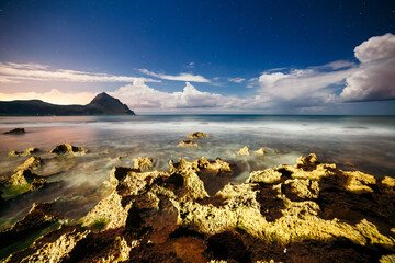 Wall Mural - the volcanic coast is illuminated by a flashlight on a starry night. monte cofano, sicily, italy.