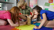 Close up of group of preschool kids build tower with wooden blocks in playroom