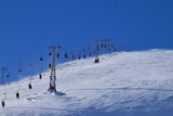 Fototapeta Kwiaty - View of cable car with skiers on Mount Cheget