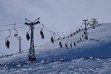 Fototapeta Kwiaty - View of the cable car with skiers on Cheget