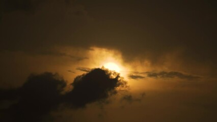 Wall Mural - 4K shot of birds flying in front of sun surrounded by dark clouds during the monsoon season in India. Birds fly in front of sun. Natural background with copy space for text. Inspiration background.