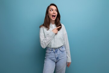 Canvas Print - young brunette lady dressed in a striped shirt and jeans points her finger to the side