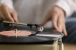 Close up view unknown female using old-fashioned equipment to listening favourite music on vinyl record old turntable player. Classical melody for retro style sound lovers, leisure, nostalgic mood