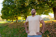 © Liubomir - Smiling sportsman resting in the park on a run, man breathing fresh air enjoying an active lifestyle, hispanic man exercising.