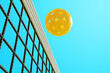 A pickleball sports ball flies over the net. 3D rendering