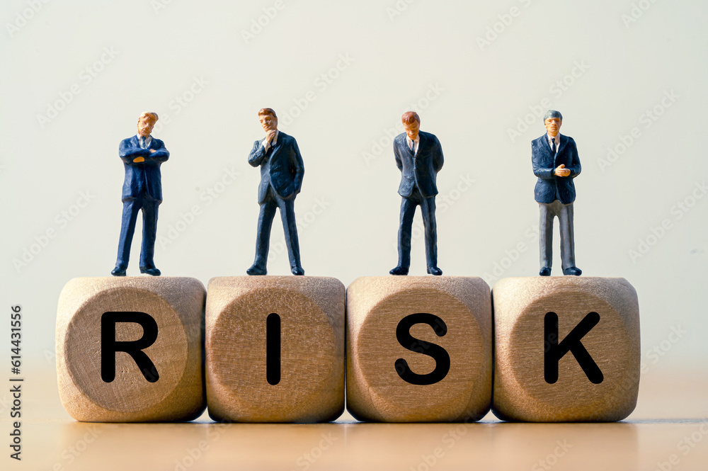 Businessmen miniature figures standing and thinking on risk wording ...