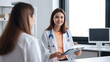 © Yeti Studio - Smiling female doctor communicating with a patient in her medical office