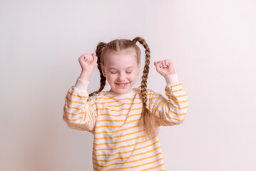 Happy and cheerful girl dancing and rejoicing on a white background