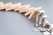 Domino effect impacts some of the heap of coins falling down, finance status, investment in domino effect concept