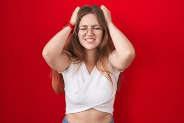 Sticker - Young caucasian woman standing over red background suffering from headache desperate and stressed because pain and migraine. hands on head.