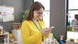 © Krakenimages.com - Young blonde woman preschool teacher smiling confident using smartphone at kindergarten